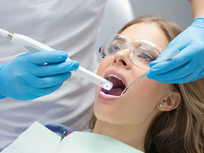 A woman receiving dental care while being attended to by a dental professional.